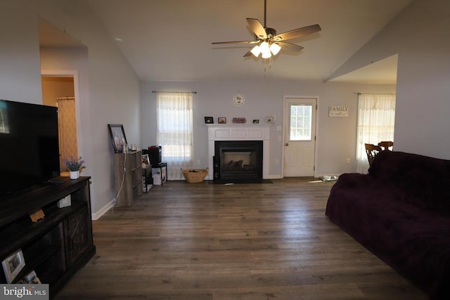 living room with ceiling fan, dark hardwood / wood-style floors, and vaulted ceiling