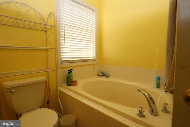 bathroom with toilet and tiled bath