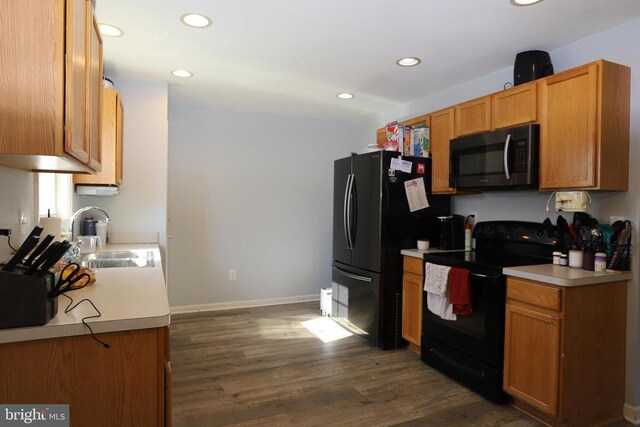 kitchen featuring sink, black appliances, and dark hardwood / wood-style floors