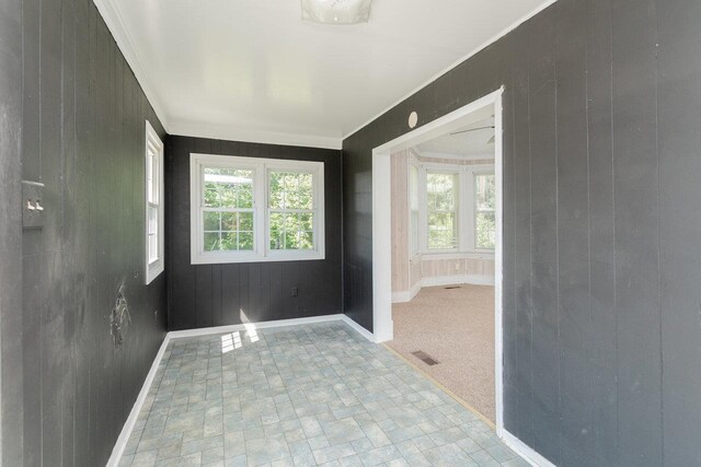 1221 Keezletown Rd, Weyers Cave, VA 24486 - spare room with crown molding, wood walls, and brick patterned floors