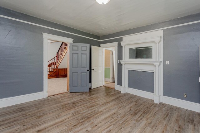 1221 Keezletown Rd, Weyers Cave, VA 24486 - unfurnished living room featuring wood finished floors, stairway, and a fireplace