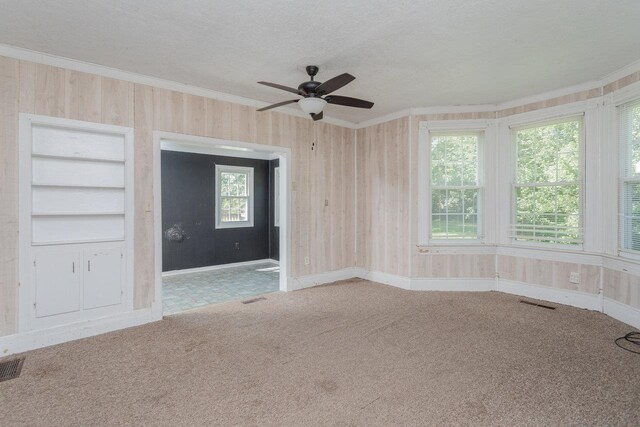 1221 Keezletown Rd, Weyers Cave, VA 24486 - carpeted spare room with crown molding, a ceiling fan, a textured ceiling, and wood walls