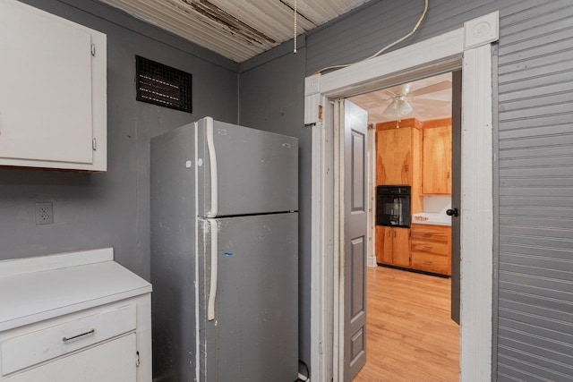 1221 Keezletown Rd, Weyers Cave, VA 24486 - kitchen with freestanding refrigerator, oven, white cabinetry, light wood-style floors, and light countertops