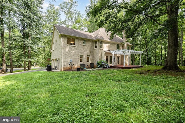  - rear view of house featuring a pergola, a garage, brick siding, a lawn, and asphalt driveway