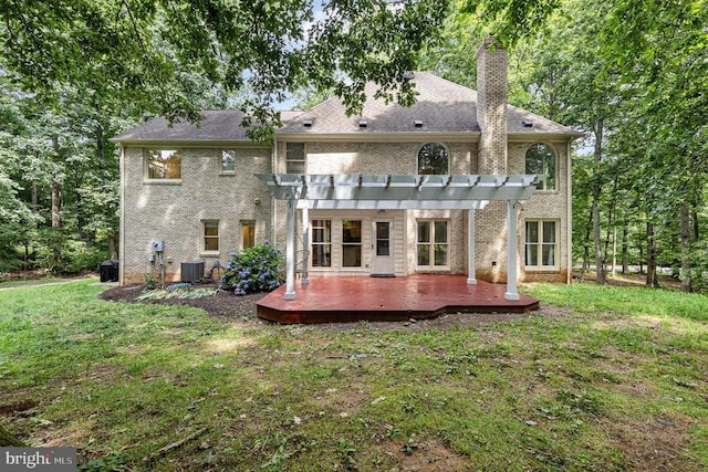  - back of house featuring a pergola, brick siding, a lawn, a deck, and a chimney
