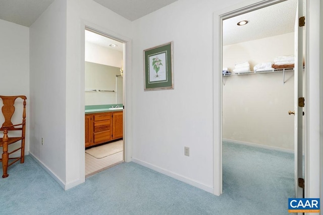 unfurnished bedroom featuring baseboards, connected bathroom, and light colored carpet