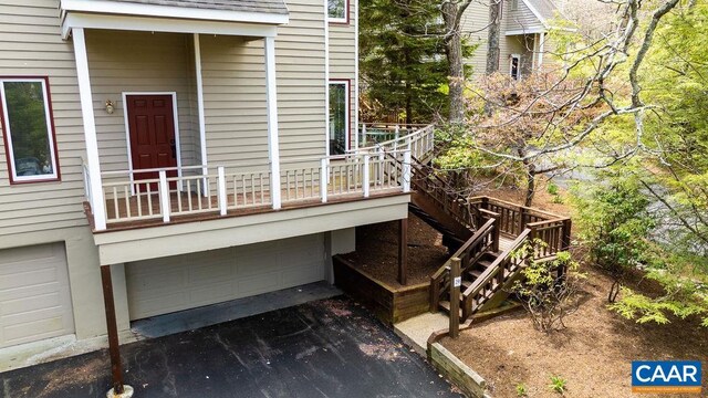 exterior space with an attached garage, driveway, and stairway