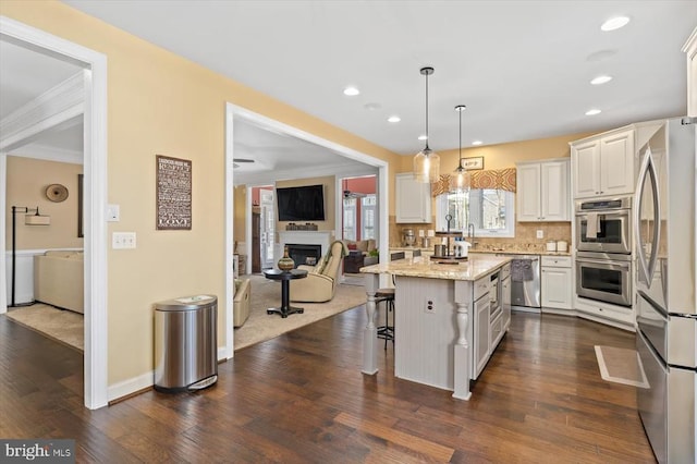 11135 Vanderbilt Cv, Spotsylvania, VA 22551 - kitchen featuring stainless steel appliances, a fireplace, white cabinets, a kitchen bar, and recessed lighting