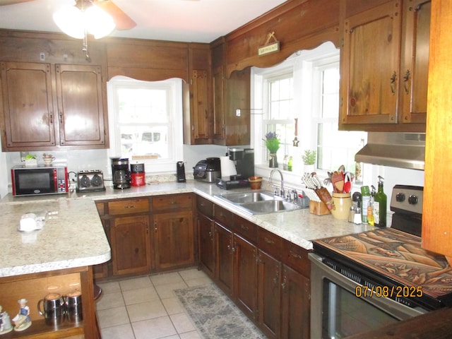 835 Rosser Ave, Waynesboro, VA 22980 - kitchen with stainless steel electric range oven, ventilation hood, black microwave, light tile patterned floors, and plenty of natural light