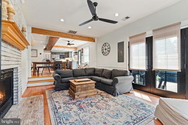  - living room with ceiling fan, a brick fireplace, wood finished floors, beamed ceiling, and recessed lighting