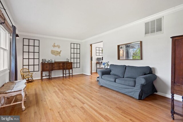  - living area with light wood finished floors and crown molding