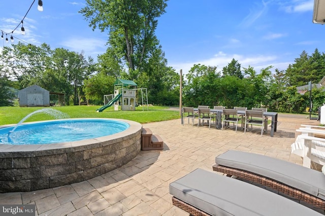  - view of pool with a yard, a patio, outdoor dining space, a playground, and a shed