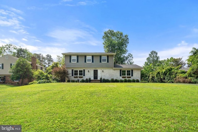  - colonial home with a front lawn and stone siding