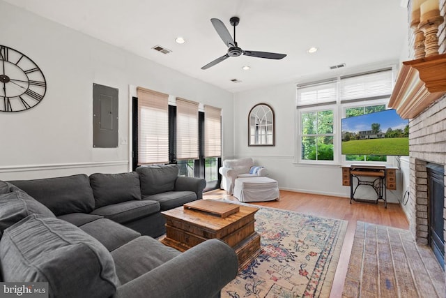  - living area with electric panel, ceiling fan, a brick fireplace, wood finished floors, and recessed lighting