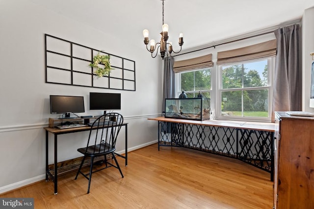  - home office with light wood-style flooring and a chandelier
