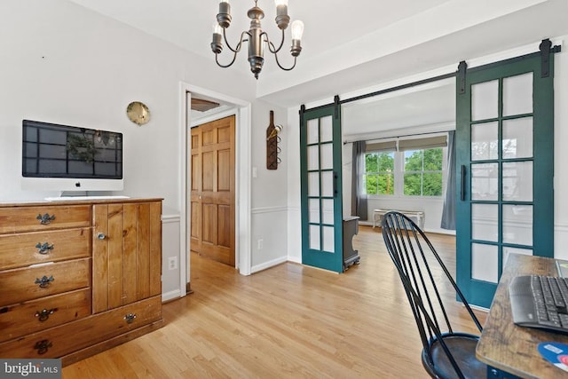  - dining area with a barn door, light wood-style floors, a chandelier, and a wall mounted air conditioner