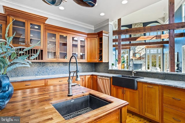  - kitchen with a sink, wooden counters, dishwasher, ornamental molding, and backsplash