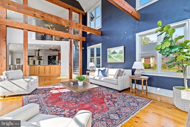  - living area featuring high vaulted ceiling, wood finished floors, baseboards, healthy amount of natural light, and recessed lighting