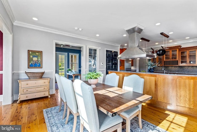  - dining space featuring crown molding, light wood finished floors, recessed lighting, and french doors