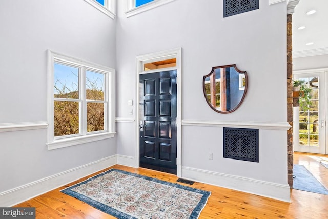  - entryway featuring wood finished floors, baseboards, and a high ceiling