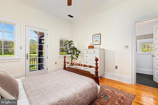  - bedroom featuring wood finished floors, access to outside, baseboards, and a ceiling fan