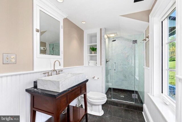  - full bathroom featuring toilet, a wainscoted wall, built in shelves, a stall shower, and vanity