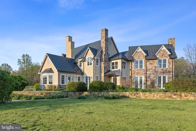  - view of front of property with a standing seam roof, a chimney, metal roof, and french doors