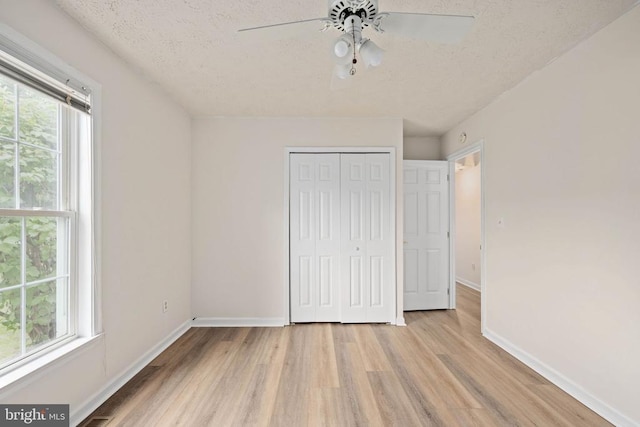 11810 Falcon Ridge Dr, Fredericksburg, VA 22407 - unfurnished bedroom featuring multiple windows, light wood-style floors, baseboards, and a textured ceiling