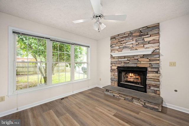 11810 Falcon Ridge Dr, Fredericksburg, VA 22407 - unfurnished living room featuring wood finished floors, a fireplace, baseboards, a ceiling fan, and a textured ceiling