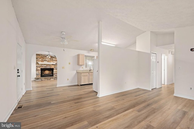 11810 Falcon Ridge Dr, Fredericksburg, VA 22407 - unfurnished living room with a ceiling fan, light wood finished floors, a fireplace, baseboards, and vaulted ceiling