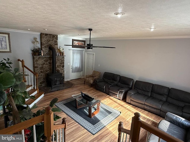 11223 Beales Branch Ln, Remington, VA 22734 - living room with wood finished floors, a ceiling fan, crown molding, a textured ceiling, and a wood stove
