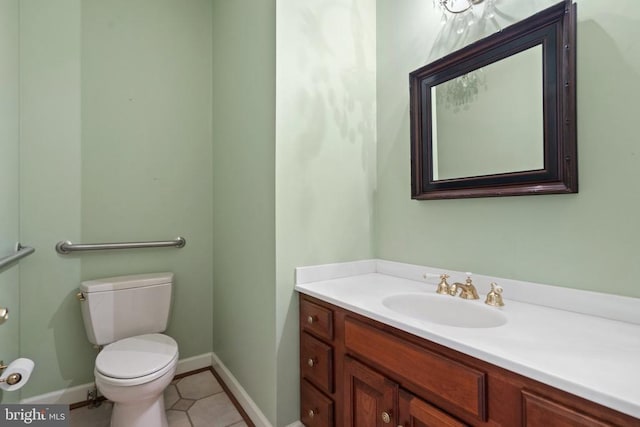  - half bathroom with vanity, toilet, baseboards, and tile patterned flooring