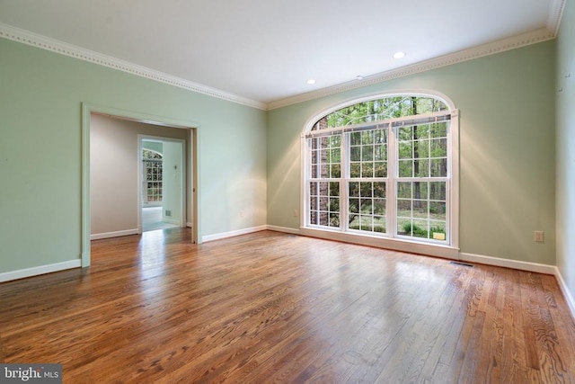  - spare room with ornamental molding, baseboards, recessed lighting, and wood finished floors