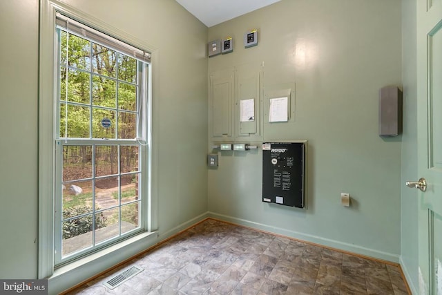  - doorway to outside with baseboards, a healthy amount of sunlight, visible vents, and stone finish flooring