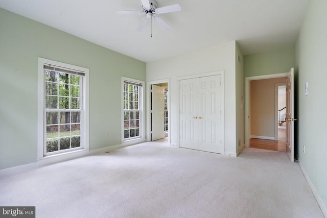  - unfurnished bedroom featuring carpet flooring, a closet, baseboards, and a ceiling fan