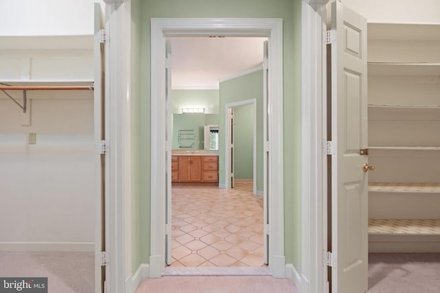  - interior space with baseboards, light tile patterned floors, and crown molding