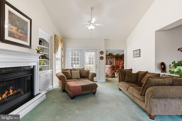11918 Boulder Ct, Spotsylvania, VA 22553 - carpeted living room featuring vaulted ceiling, a ceiling fan, a warm lit fireplace, and built in features