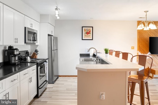 1545 Cliffs, Roseland, VA 22967 - kitchen featuring stainless steel appliances, a kitchen breakfast bar, light wood finished floors, a chandelier, and tasteful backsplash