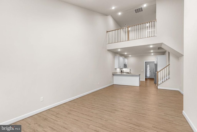5711 Finley Rose Ct, Fredericksburg, VA 22407 - unfurnished living room featuring light wood-style flooring, stairway, recessed lighting, and high vaulted ceiling