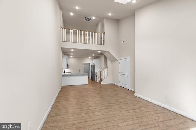 5711 Finley Rose Ct, Fredericksburg, VA 22407 - unfurnished living room with light wood-style floors, stairway, a towering ceiling, and recessed lighting