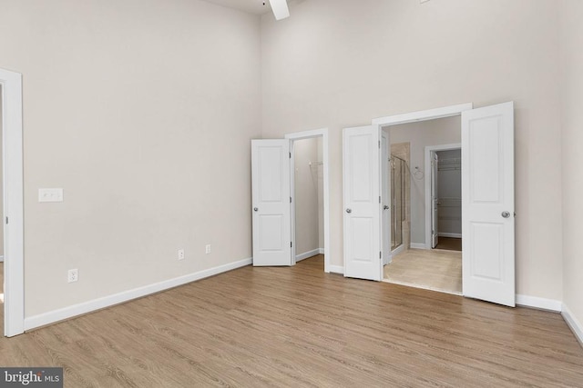 5711 Finley Rose Ct, Fredericksburg, VA 22407 - unfurnished bedroom featuring a spacious closet, a towering ceiling, light wood-style flooring, and a closet