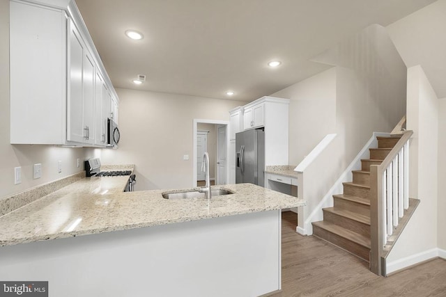 5711 Finley Rose Ct, Fredericksburg, VA 22407 - kitchen featuring stainless steel appliances, a peninsula, light wood finished floors, light stone counters, and recessed lighting