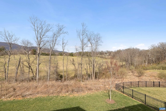 view of yard featuring fence and a rural view