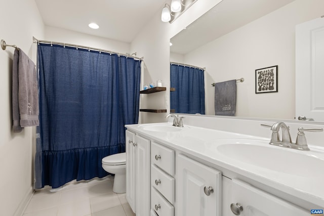bathroom with toilet, tile patterned floors, double vanity, and a sink