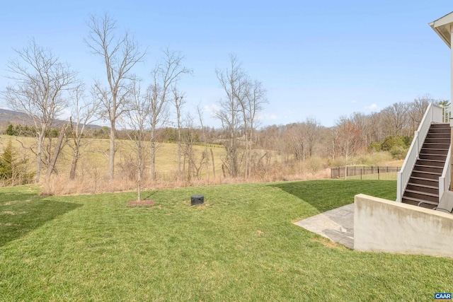 view of yard featuring a patio area, stairway, and fence