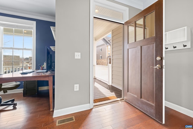 foyer with crown molding, visible vents, baseboards, and hardwood / wood-style floors