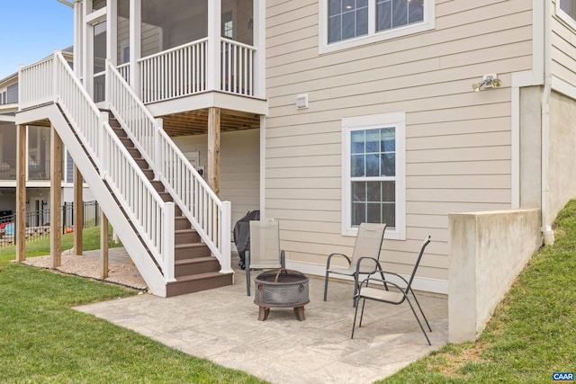 exterior space with stairway, a patio area, a fire pit, and a lawn
