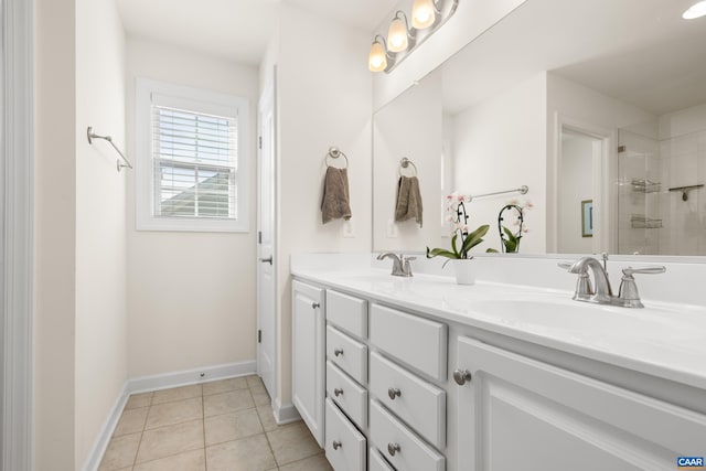 full bath with a sink, double vanity, tiled shower, and tile patterned floors