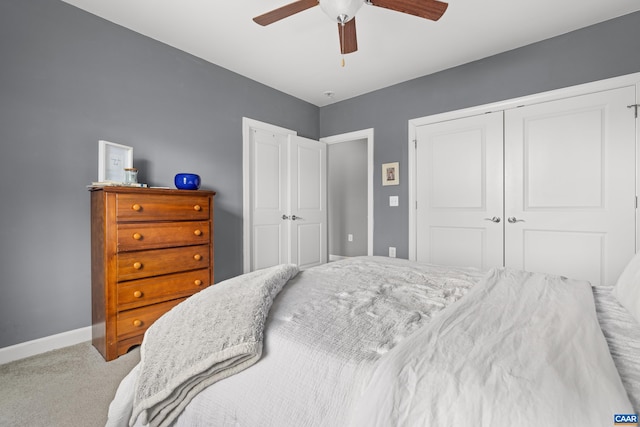 carpeted bedroom with baseboards, a closet, and ceiling fan