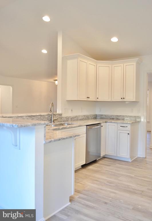 5208 Wyndemere Cir, Mineral, VA 23117 - kitchen featuring stainless steel dishwasher, a sink, white cabinets, light wood-type flooring, and recessed lighting